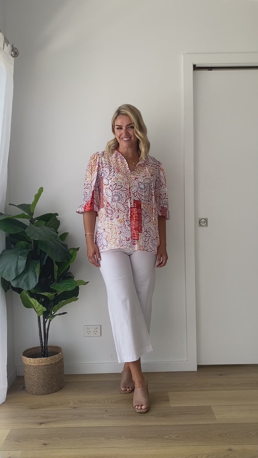 Video with a model wearing white cropped bengaline pants with a colourful printed top